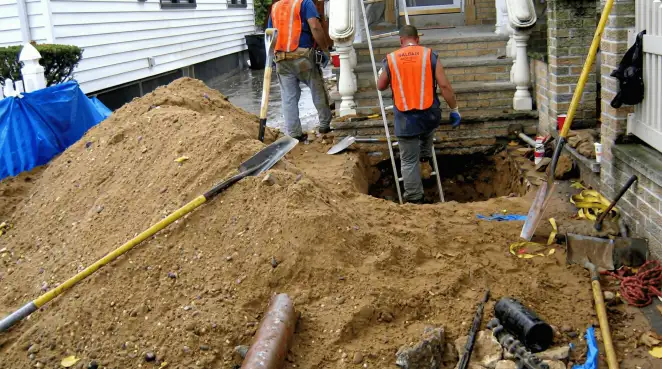 Contractors performing foundation protection and exterior drainage excavation near residential home steps in Baton Rouge, LA